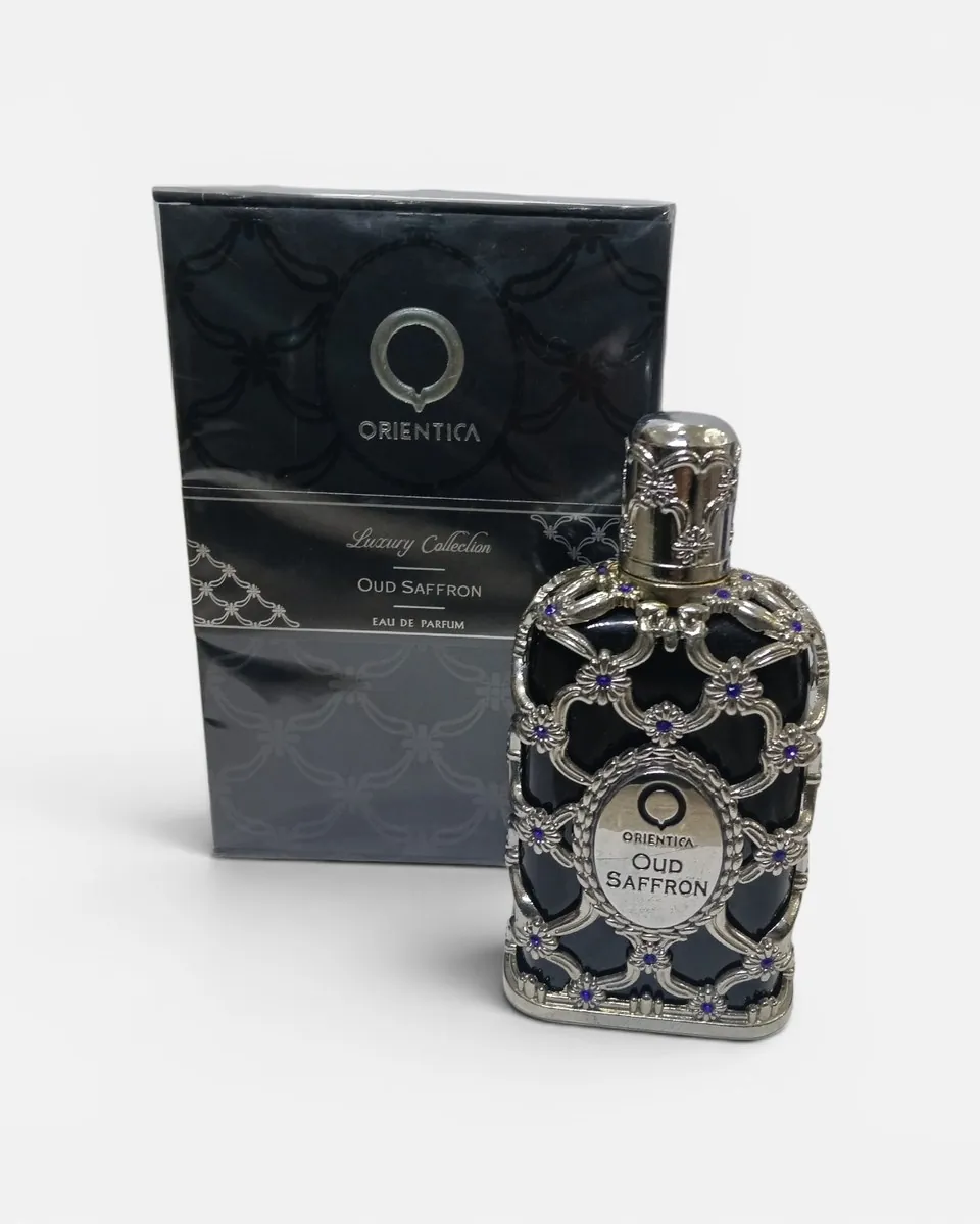 Perfume Oud Saffron de Orientica, frasco calado plateado, junto a su caja negra